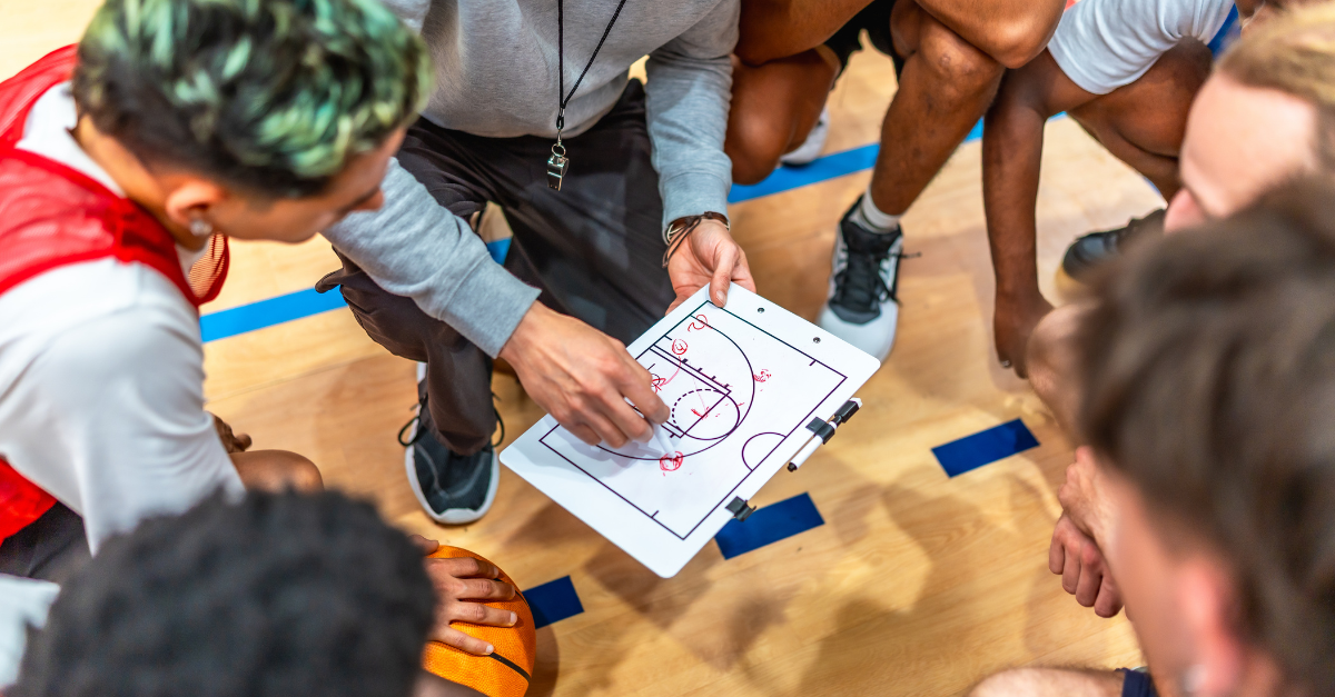 Executive leader coaching team using championship leadership lessons in high-stakes strategy session