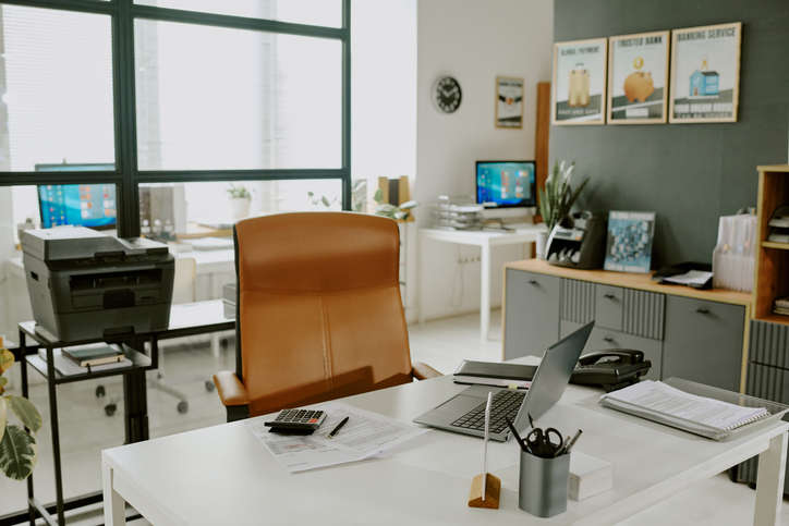 Office desk with empty chair and laptop, representing nonprofit recruitment for a new role and leadership hiring process.